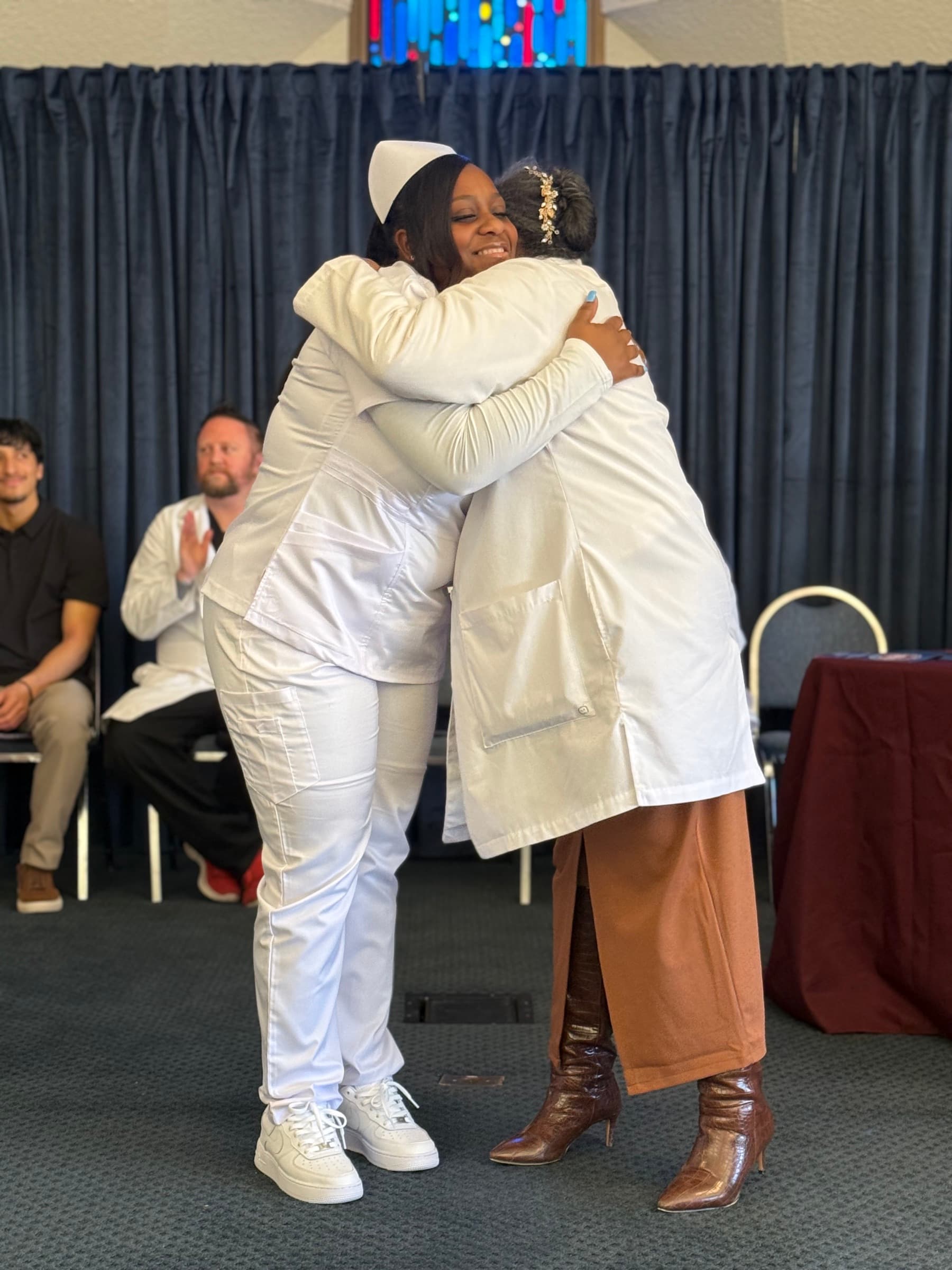 A CCI nursing student and instructor embracing during a pinning ceremony.