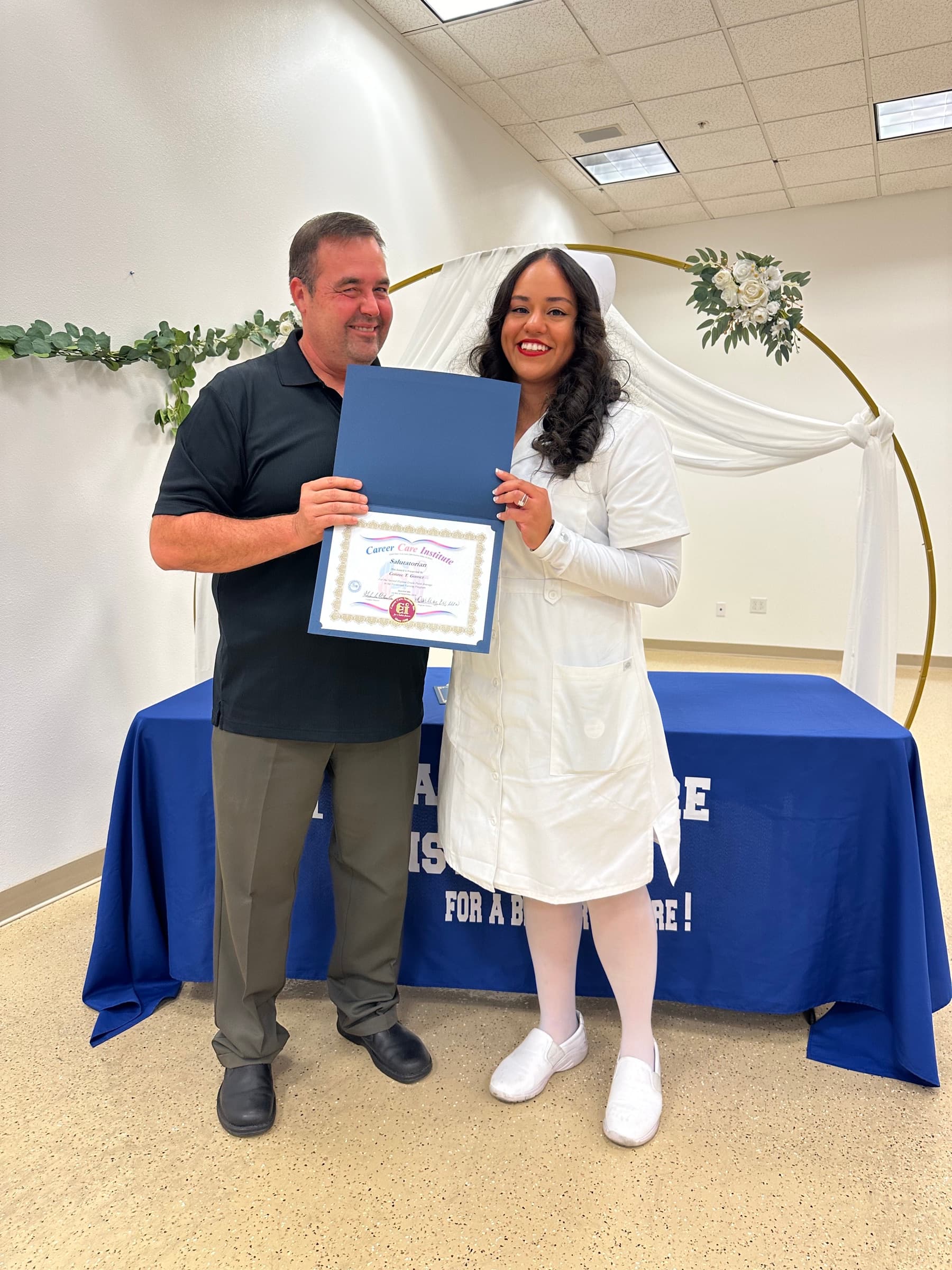 CCI salutatorian Connie Gomez holding her certificate beside instructor Paul Arroyo.