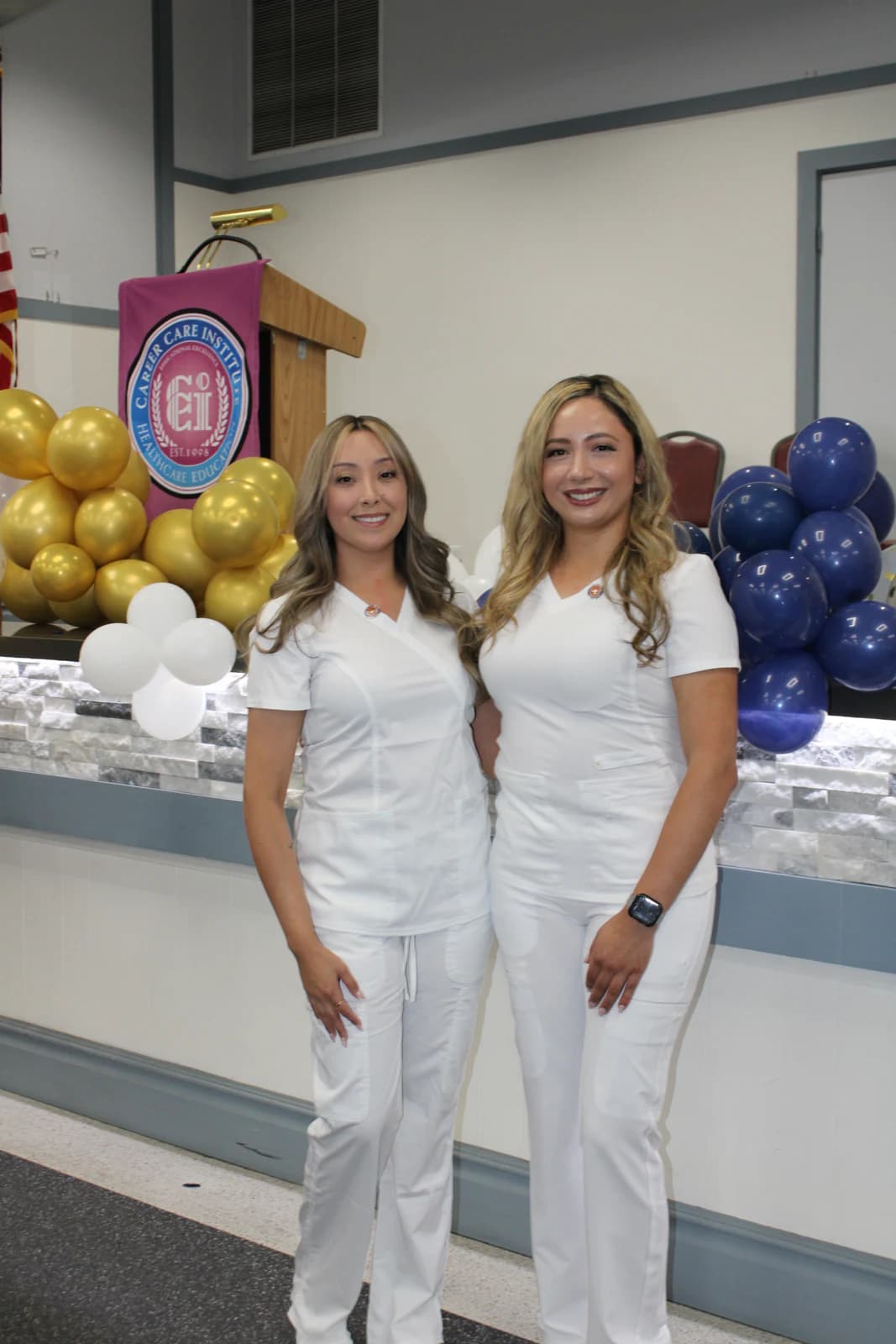 Registered Nursing students in white uniforms stand together during a CCI pinning ceremony.