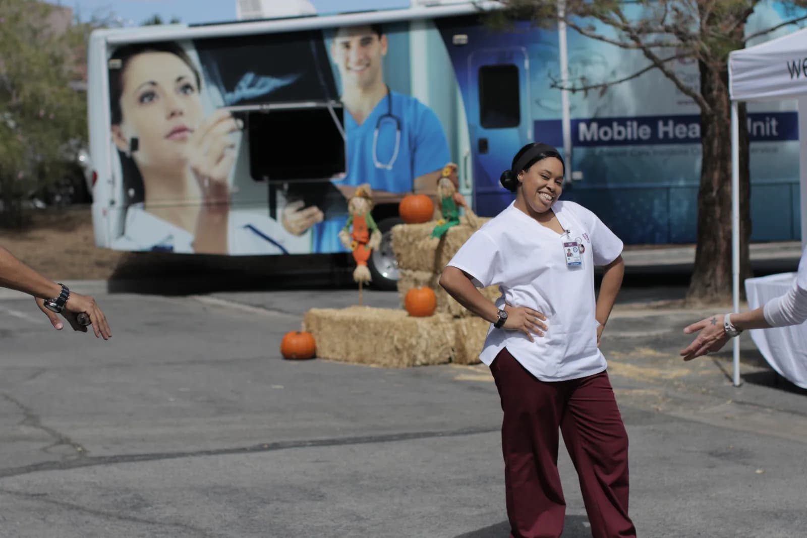 A CCI student smiling beside the CCI Mobile Health Unit during a student appreciation activity