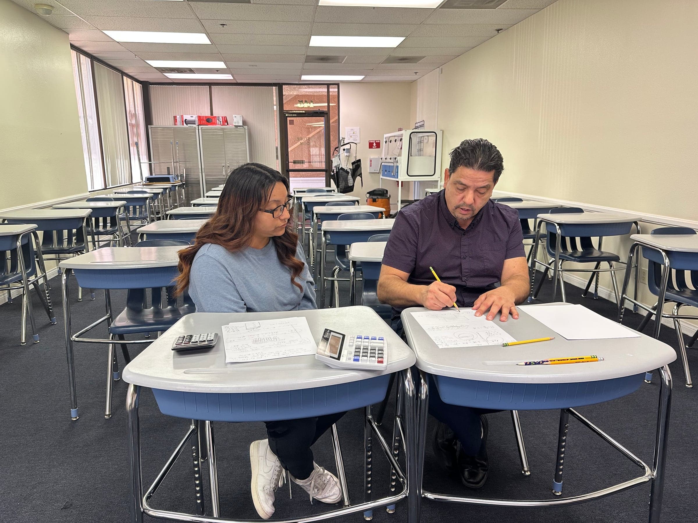 A CCI student receiving one-on-one tutoring in a classroom