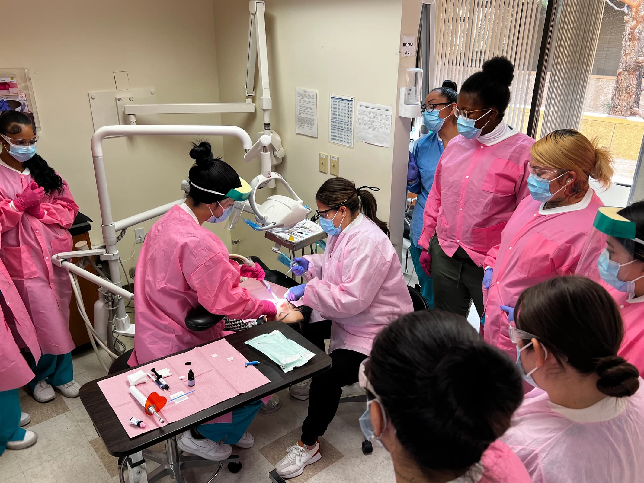 Dental Assisting students practice chairside skills with dental equipment.