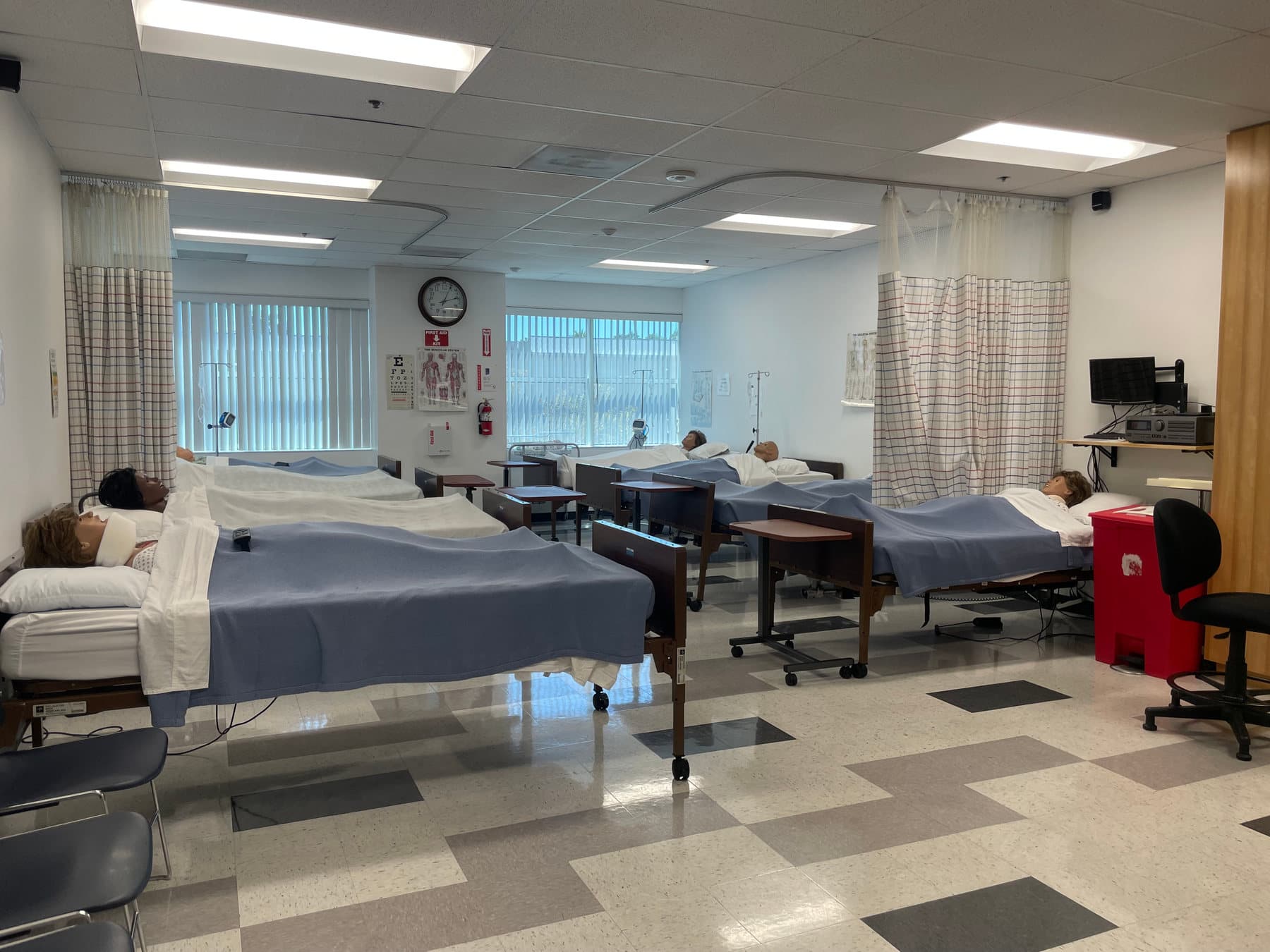 Hospital beds, privacy curtains, and simulation manikins in the CCI Oxnard Vocational Nursing lab.