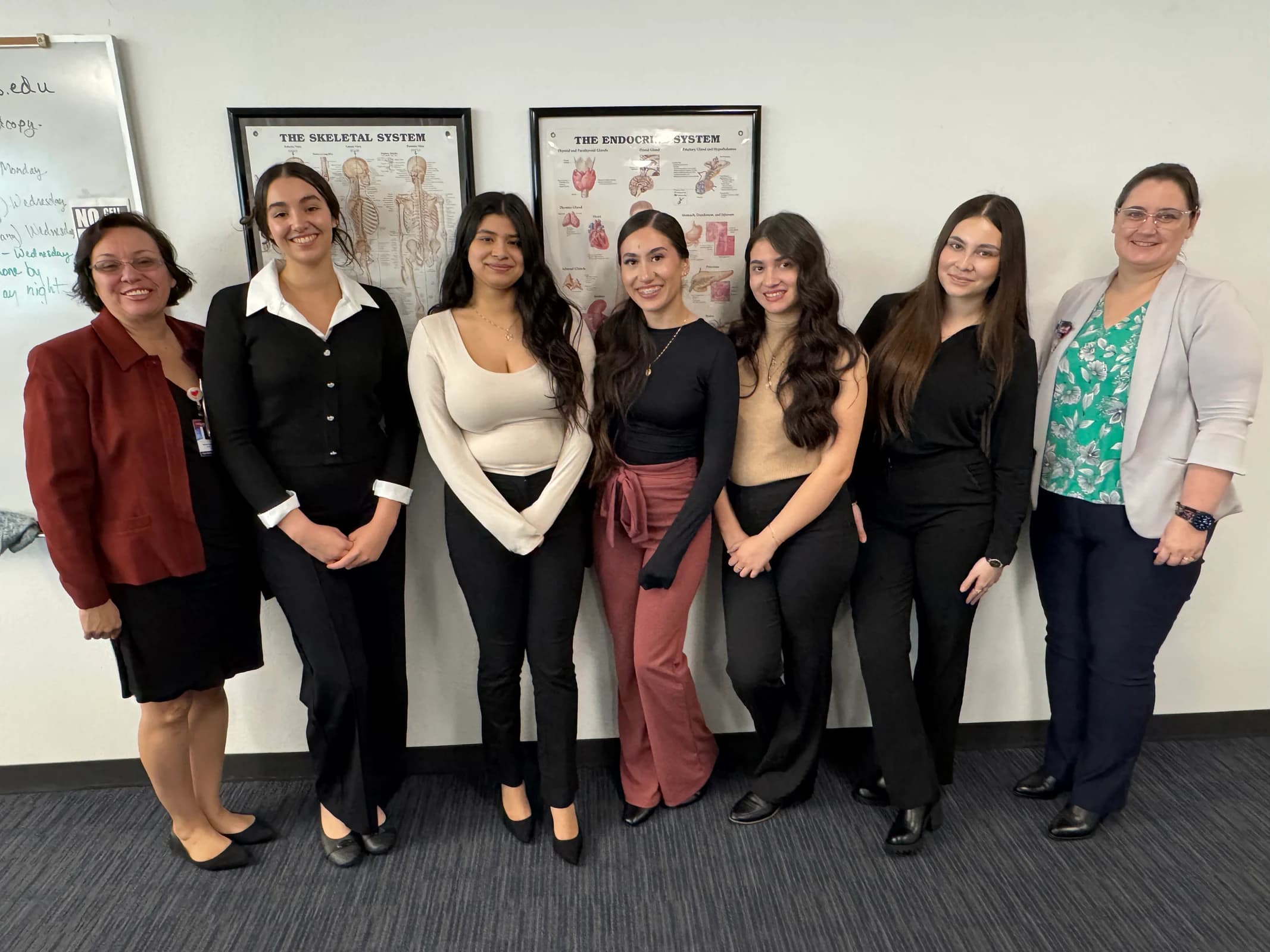 Medical Assisting students pose with staff in professional attire.